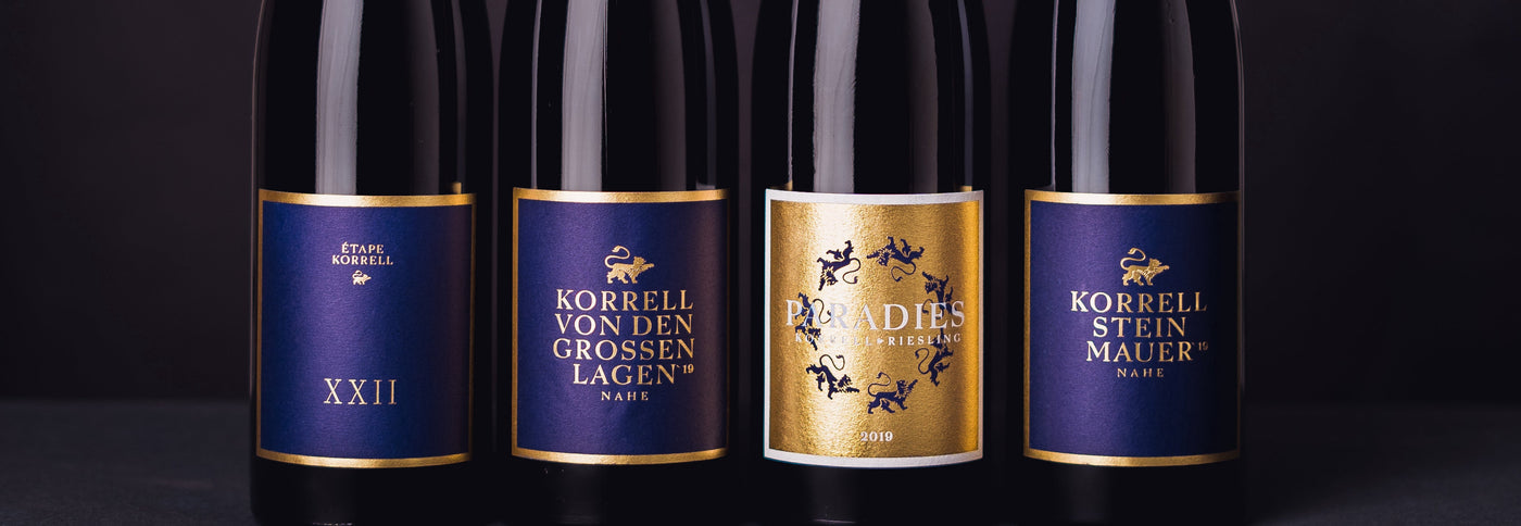 vier Flaschen Korrell Wein vor schwarzem Hintergrund